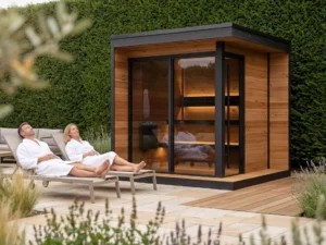 Couple relaxing on loungers beside luxury outdoor sauna in landscaped garden