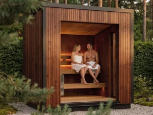 Lumo outdoor sauna with open front showing tiered seating and warm LED lighting in brown thermowood forest setting